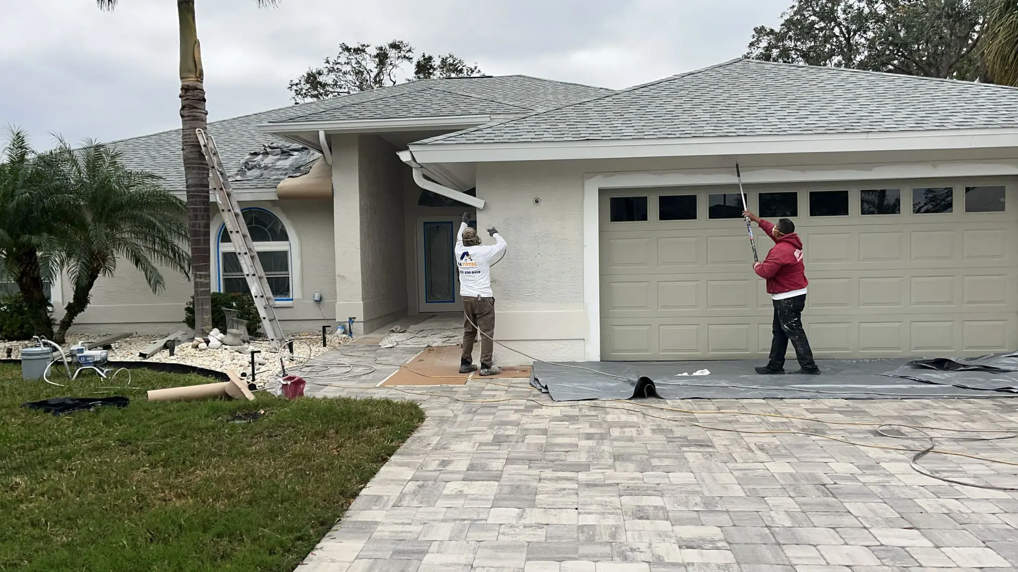 Two painters painting the gutter
