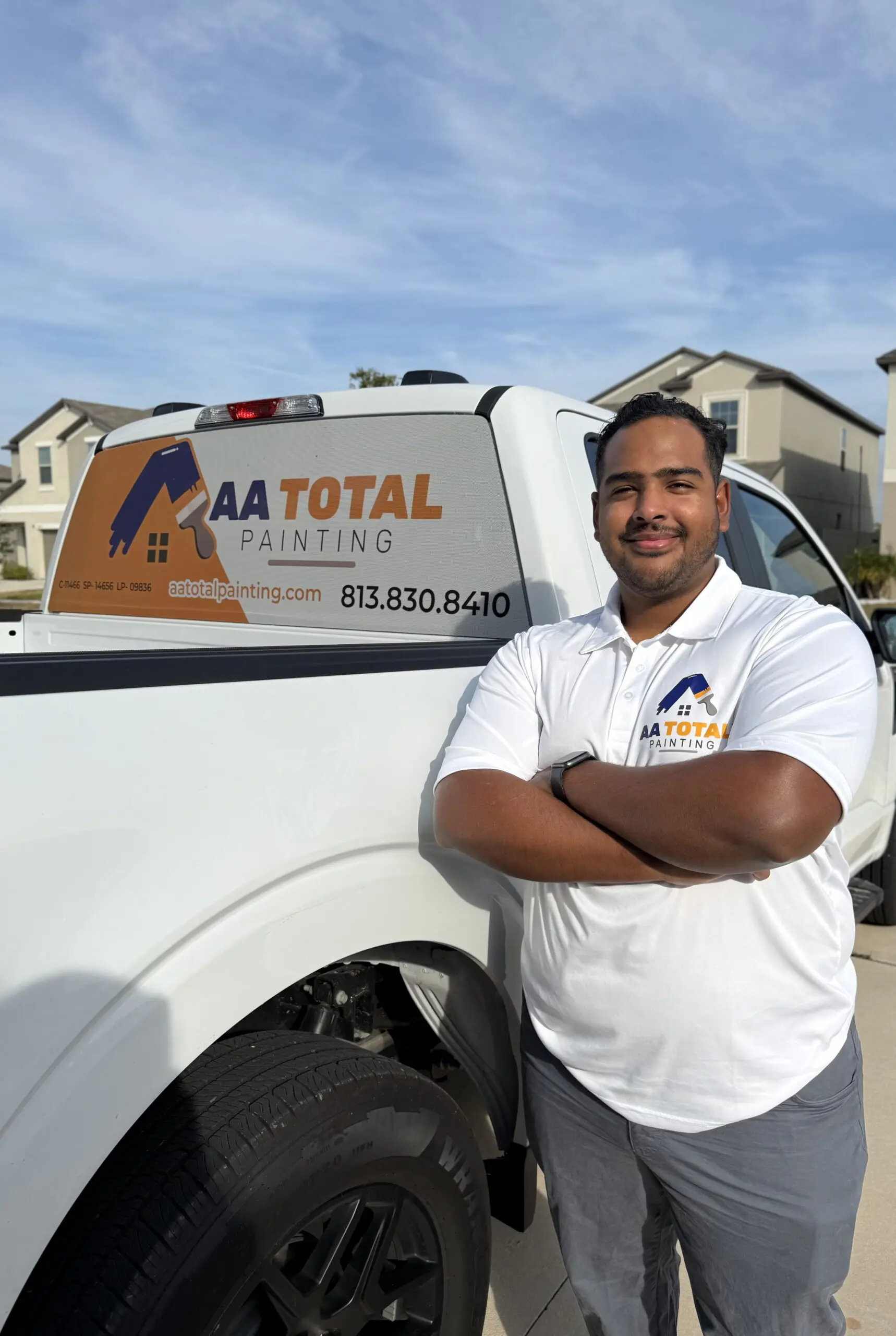 A white and orange van with “AA TOTAL PAINTING” branding, including a phone number and website, is parked in a paved driveway in front of a beige house with a brown garage door, under a sunny sky with palm trees in the background. A white and orange van with "AA TOTAL PAINTING" branding, including a phone number and website, is parked in a paved driveway in front of a beige house with a brown garage door, under a sunny sky with palm trees in the background.